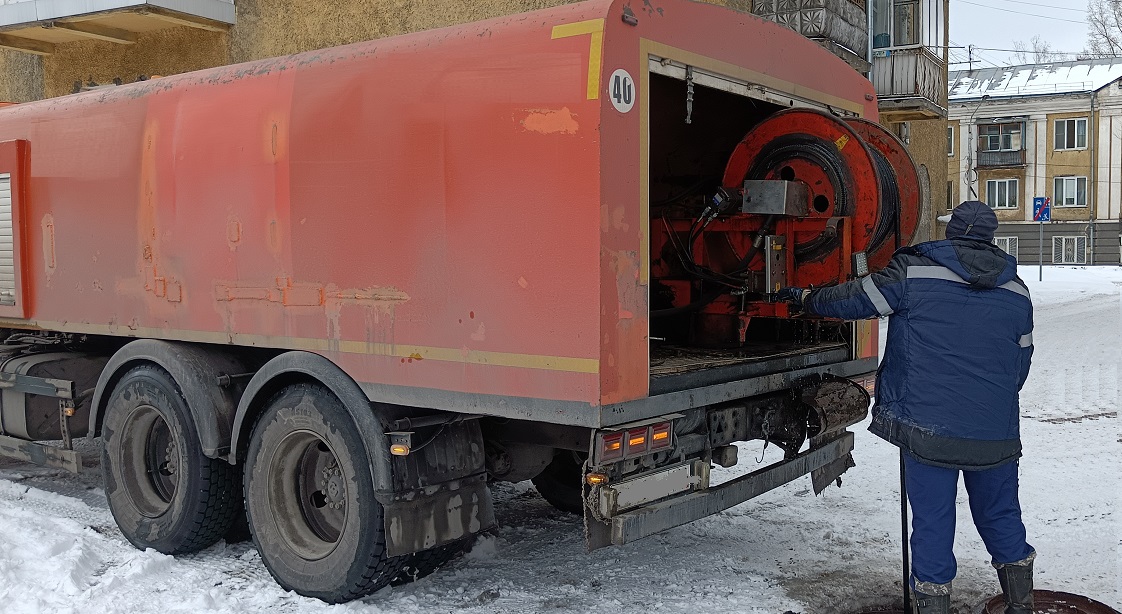 Каналопромывочная машина и работник прочищают засор в канализационной системе в Верхнем Баскунчаке